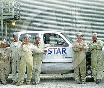STAR Cooling Towers employees standing in front of truck wearing overalls and safety helmets